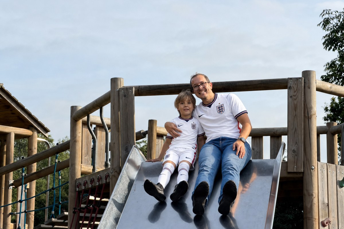 Scott and Lucas sitting together at the top of a playground slide